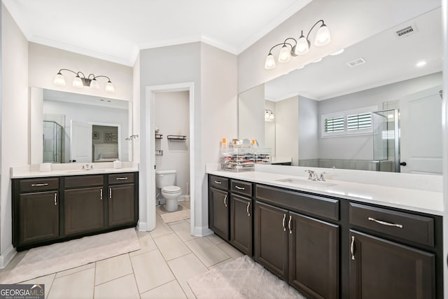 bathroom featuring a shower stall, two vanities, ornamental molding, and a sink