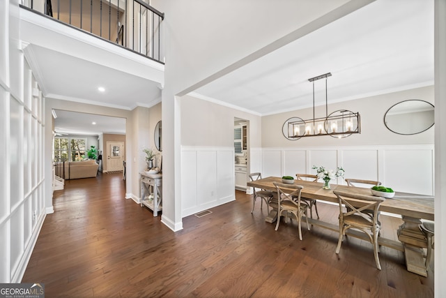 dining area featuring dark wood finished floors and ornamental molding