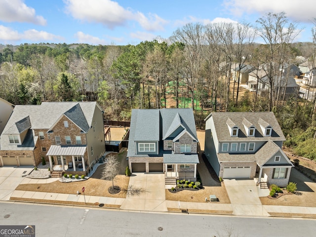 drone / aerial view featuring a residential view and a wooded view