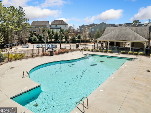 pool featuring a residential view, a patio, and fence