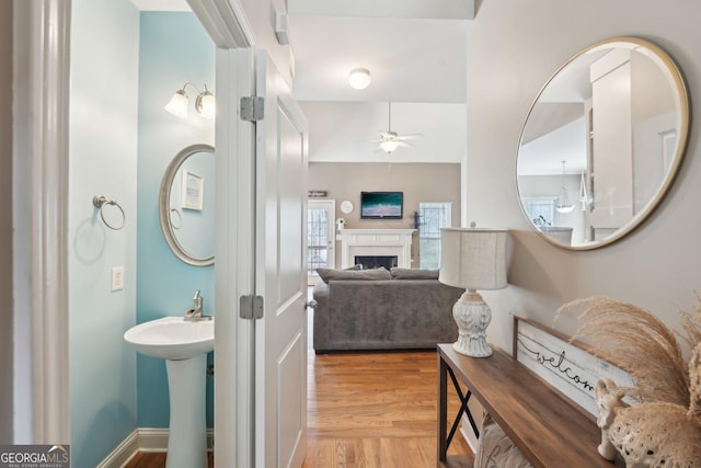 bathroom featuring wood finished floors, a fireplace, and ceiling fan