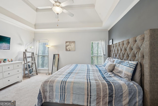 bedroom with ceiling fan, a raised ceiling, carpet, and ornamental molding