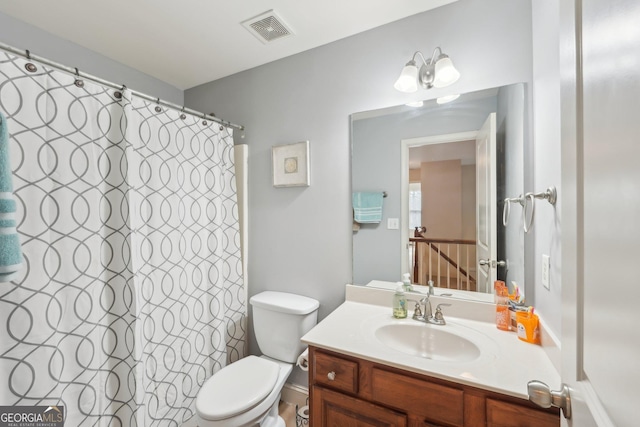 bathroom featuring visible vents, toilet, vanity, and a shower with curtain