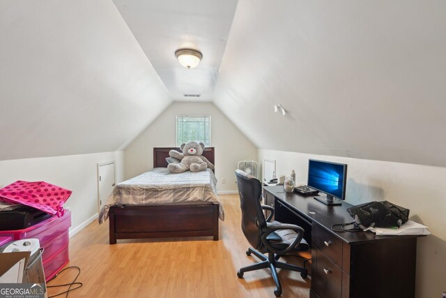 bedroom with visible vents, lofted ceiling, baseboards, and light wood finished floors