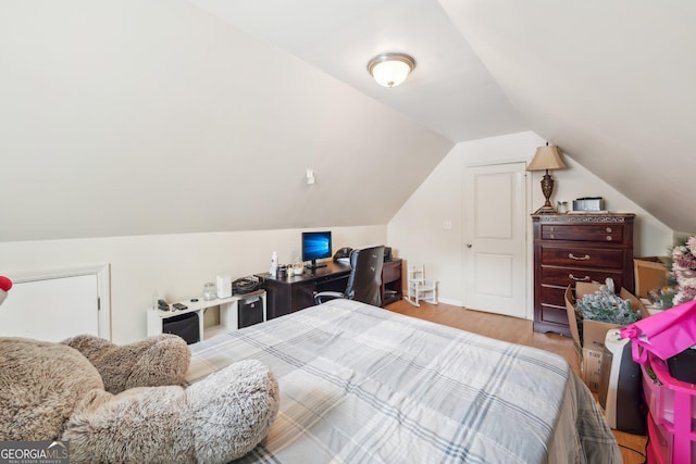 bedroom with wood finished floors and vaulted ceiling