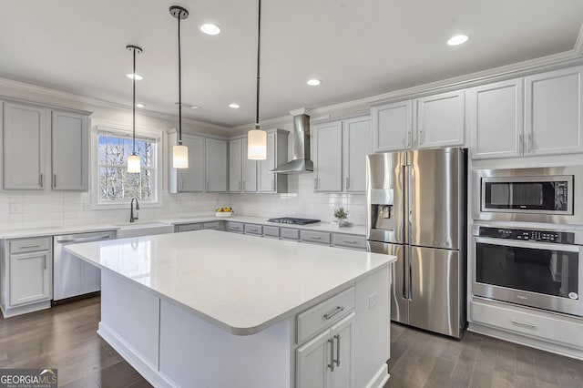 kitchen with dark wood-style flooring, a sink, light countertops, appliances with stainless steel finishes, and wall chimney exhaust hood