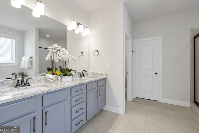 bathroom with double vanity, marble finish floor, baseboards, and a sink