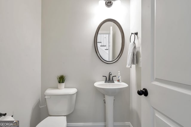 bathroom with toilet and baseboards