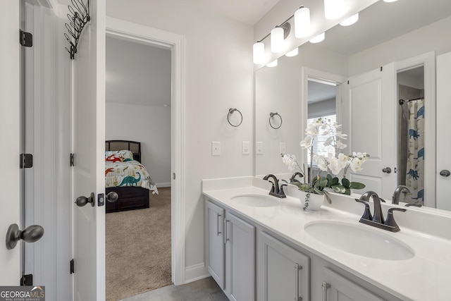 bathroom featuring double vanity, tile patterned flooring, ensuite bathroom, and a sink