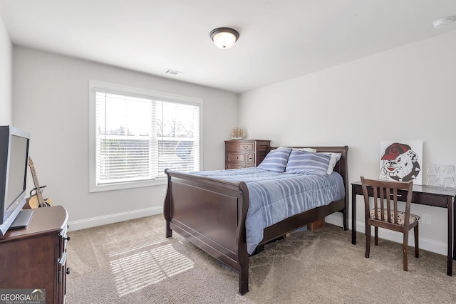 bedroom featuring visible vents, light colored carpet, and baseboards