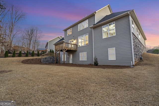 rear view of property featuring a wooden deck and a yard