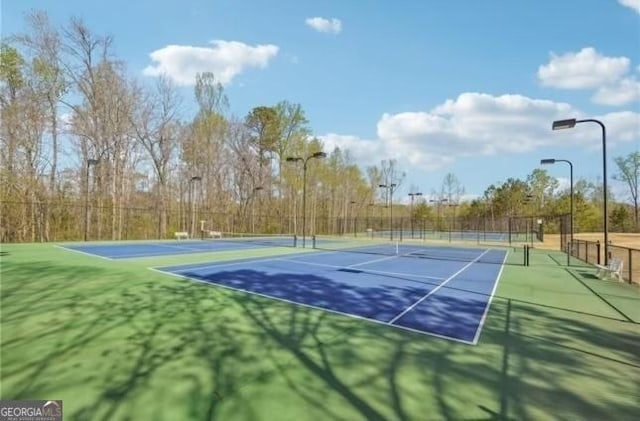 view of sport court featuring fence