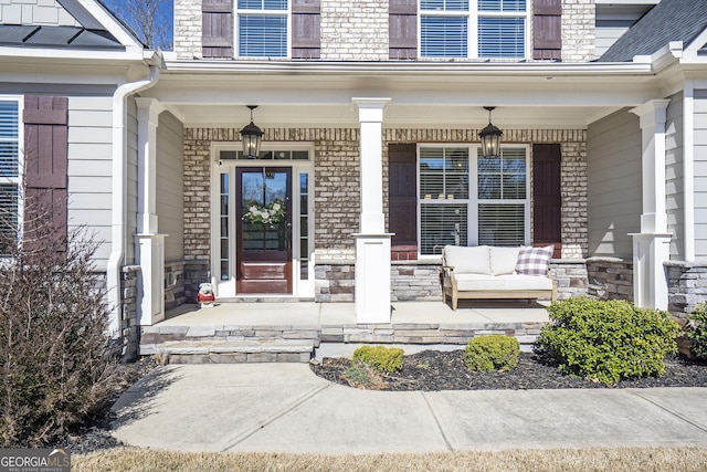 doorway to property featuring covered porch and a standing seam roof