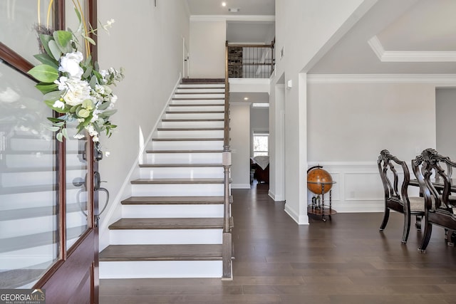 stairs featuring a decorative wall, wood finished floors, wainscoting, and ornamental molding