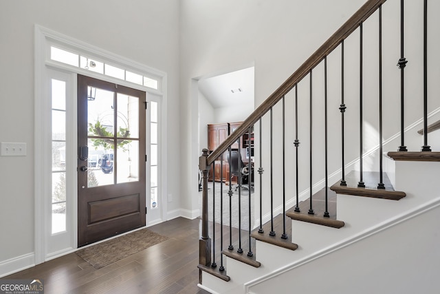 foyer entrance with dark wood finished floors, stairway, a healthy amount of sunlight, and visible vents