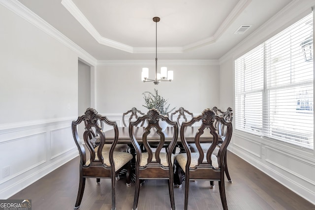 dining space with visible vents, an inviting chandelier, dark wood-style floors, and a decorative wall