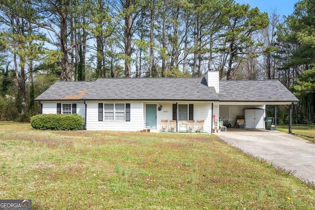 single story home featuring driveway, covered porch, a front yard, a carport, and a chimney