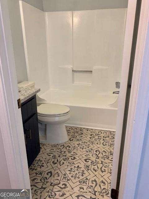 full bathroom with tile patterned flooring, toilet, vanity, and washtub / shower combination