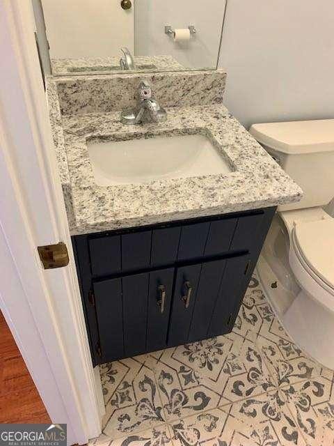 bathroom featuring toilet, vanity, and tile patterned flooring