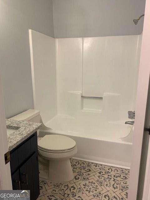 bathroom featuring tile patterned flooring, shower / bathing tub combination, toilet, and vanity