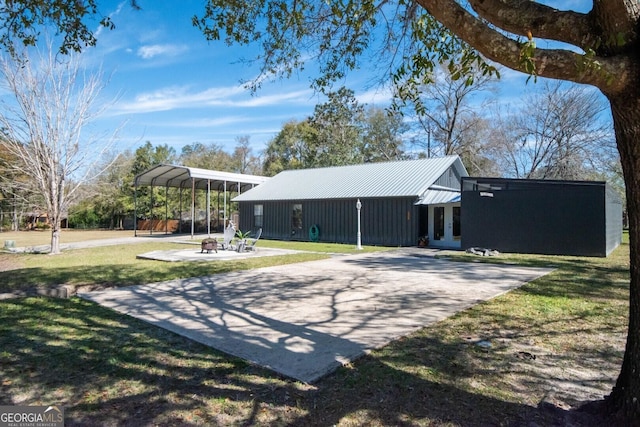 exterior space featuring a carport, a yard, a patio area, and driveway