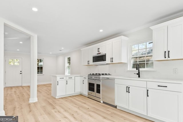 kitchen featuring stainless steel dishwasher, ornamental molding, a peninsula, backsplash, and double oven range