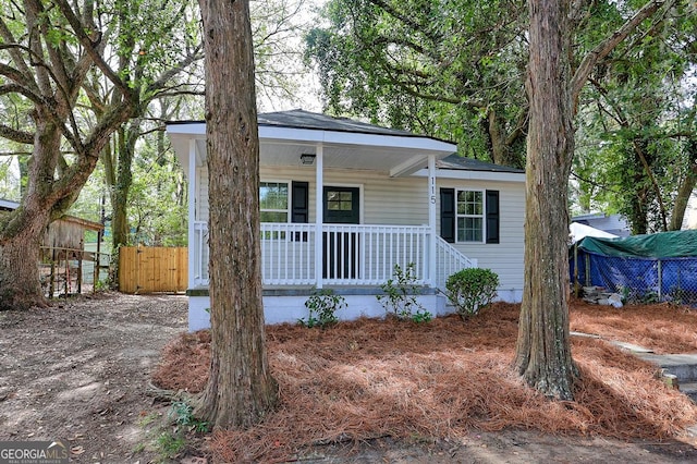 view of front of house featuring a porch and fence