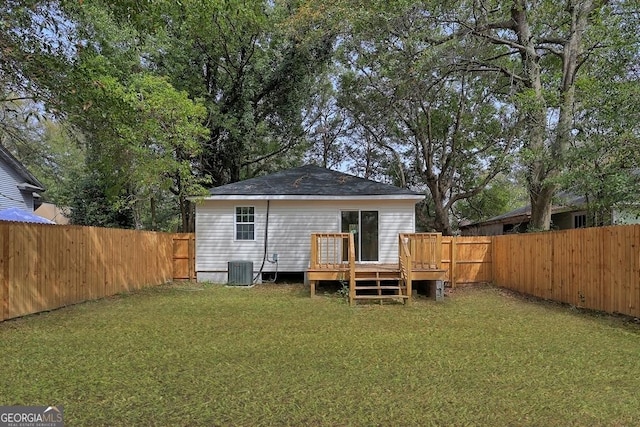 back of property with a lawn, central AC, a fenced backyard, and a deck