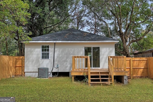 rear view of property with central air condition unit, a yard, a fenced backyard, and a wooden deck