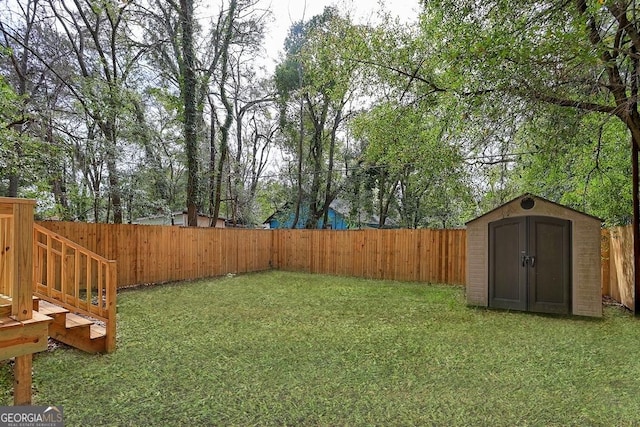 view of yard featuring an outbuilding, a storage shed, and a fenced backyard