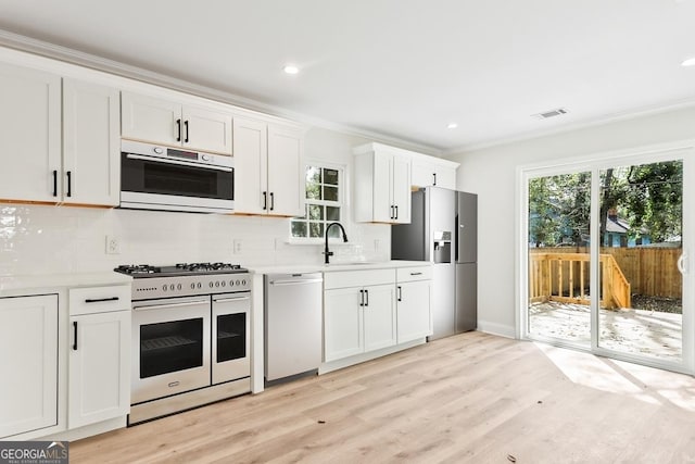 kitchen featuring ornamental molding, stainless steel fridge with ice dispenser, light countertops, range with two ovens, and dishwasher