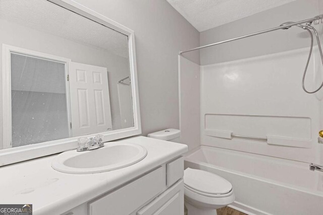 full bathroom featuring vanity, shower / tub combination, a textured ceiling, and toilet