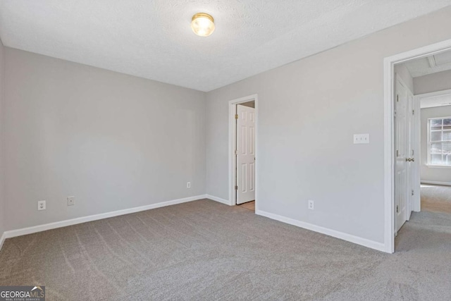 unfurnished bedroom featuring carpet flooring, baseboards, and a textured ceiling