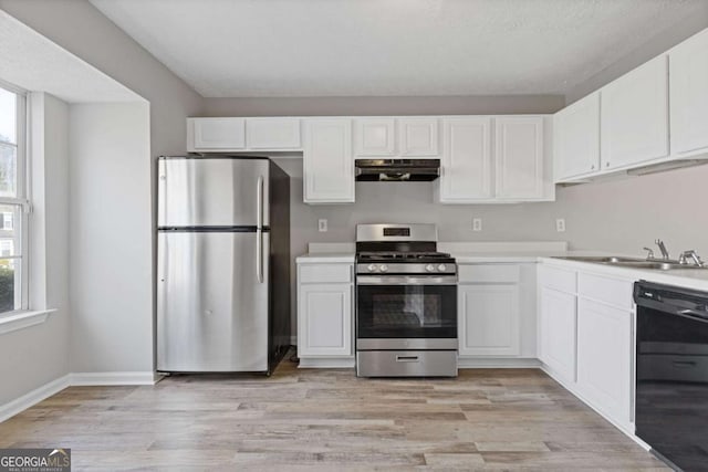 kitchen featuring white cabinets, appliances with stainless steel finishes, plenty of natural light, and under cabinet range hood
