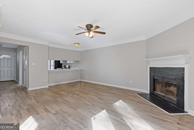 unfurnished living room with wood finished floors, baseboards, a ceiling fan, and a fireplace with raised hearth