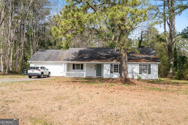 ranch-style house with a garage, driveway, covered porch, and a front lawn