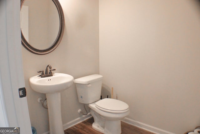 bathroom featuring toilet, baseboards, and wood finished floors