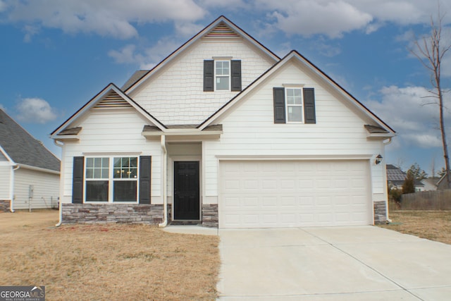 craftsman inspired home with a front yard, an attached garage, stone siding, and driveway