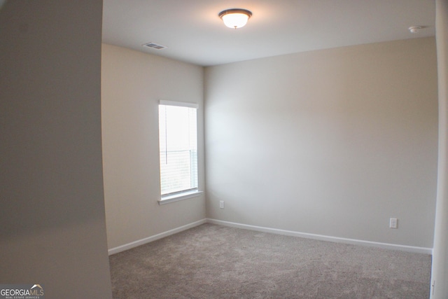 carpeted empty room with visible vents and baseboards