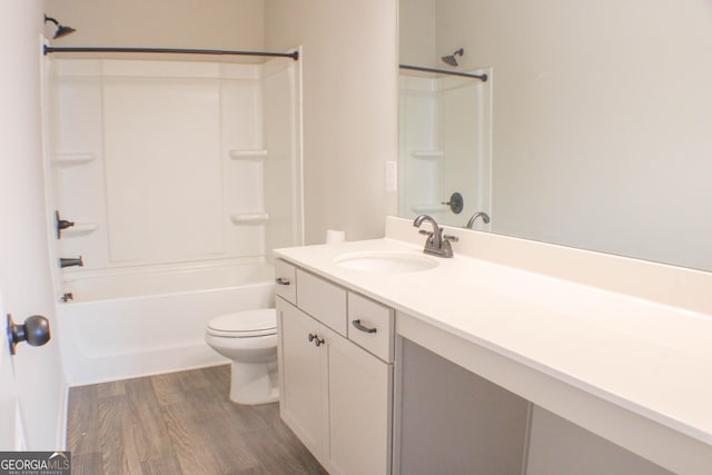 full bath with toilet, vanity, bathing tub / shower combination, and wood finished floors