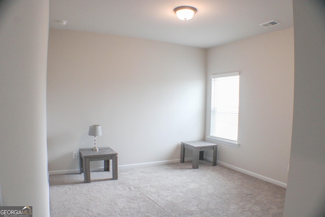 carpeted empty room featuring visible vents and baseboards