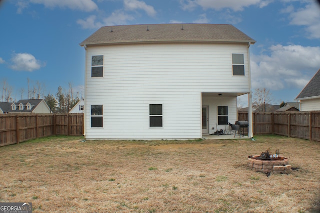 back of house featuring a fire pit, a fenced backyard, a lawn, and a patio area