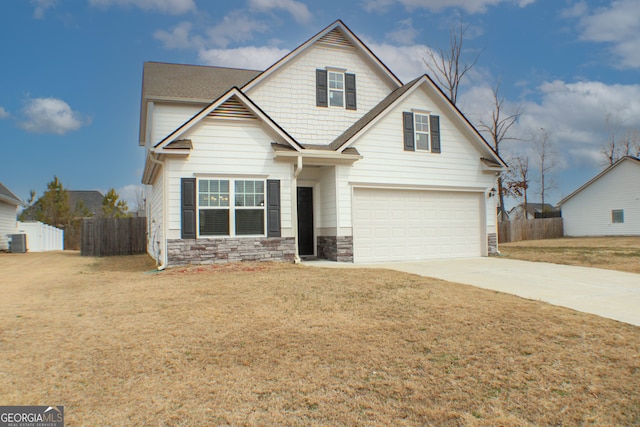 craftsman-style house featuring a garage, stone siding, concrete driveway, and fence