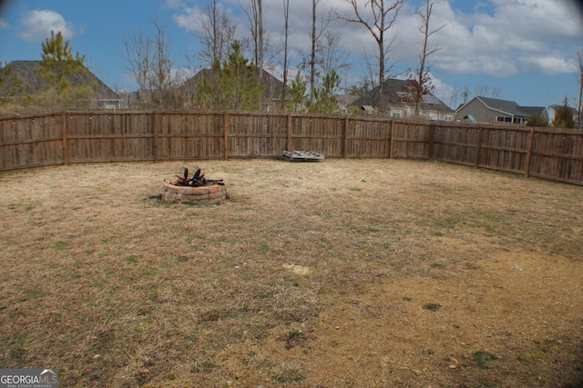 view of yard featuring a fenced backyard and an outdoor fire pit