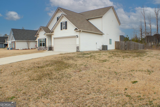 view of front of home featuring central air condition unit, a front lawn, driveway, fence, and roof with shingles