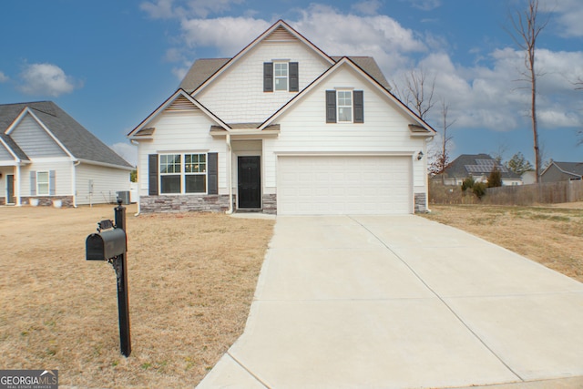 view of front facade with driveway, a front lawn, stone siding, fence, and an attached garage