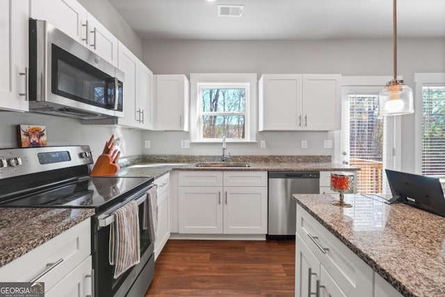 kitchen with visible vents, dark wood-style flooring, a sink, stainless steel appliances, and white cabinetry