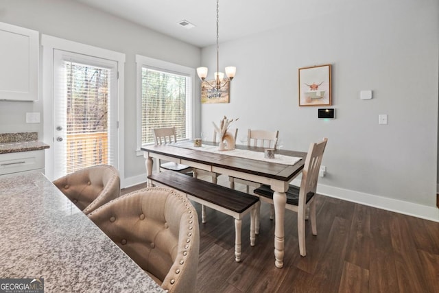 dining area featuring dark wood finished floors, visible vents, an inviting chandelier, and baseboards