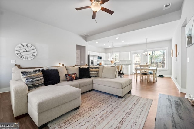 living room featuring recessed lighting, visible vents, baseboards, and light wood-style floors