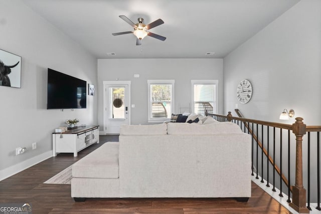 living area with visible vents, a ceiling fan, baseboards, and dark wood-style flooring